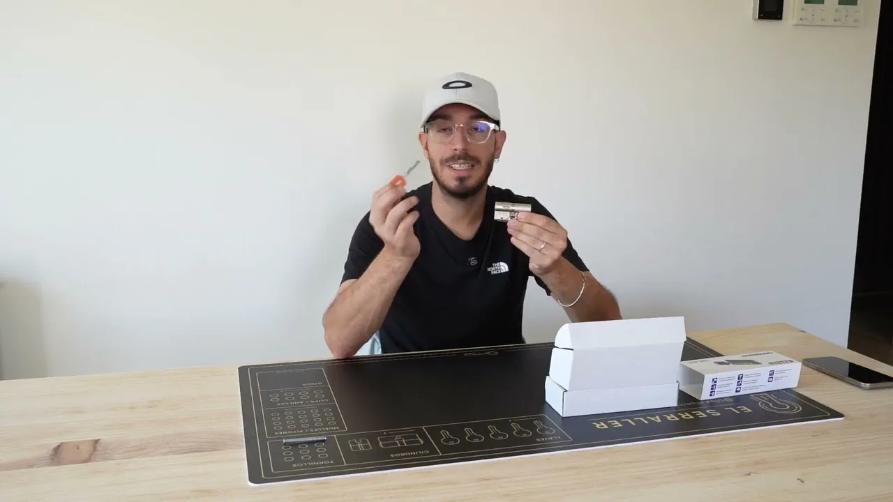 Alex en su mesa de trabajo, con el cilindro Tokoz en una mano y la llave en la otra